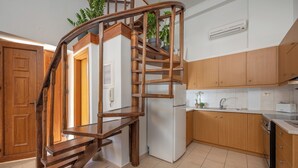 Een keuken met houten kastjes, een inbouwfornuis en een koelkast.