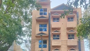 A hotel named "TERRA HOTEL" with a signboard, a red and white facade, and a parked motorcycle in front. - Terra Hotels T nagar (Chennai)