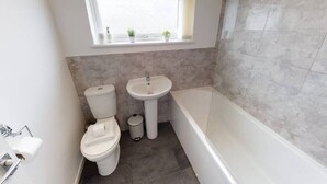 A bathroom with a toilet, sink, and bathtub. - Book Direct 10% Off > Flexley House 4 Br Workstays (Middlesbrough)