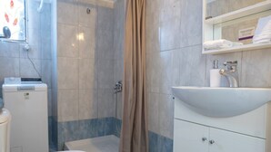 A bathroom with a toilet, shower, sink, and a mirror. - Kastella cozy flat for 2 persons my MPS (Pireas)