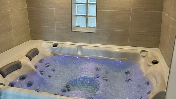 A hot tub with a window above it, tiled walls, and a visible vent. - 2 Bedroom Private vacation home in Amboise (Amboise)
