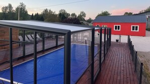 A swimming pool with a glass enclosure, a red building, and a wooden deck. - 2 self-contained country homes with heated indoor swimming pool 8-12p (Aix-en-Issart)