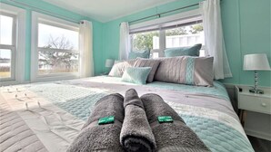A bedroom with a bed, pillows, a nightstand, and a window. - Two Waterfront homes with two private docks, two hot tubs, Seven bedrooms and 4 bathrooms with boat lift. (Cedar Point)