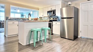 A modern kitchen with a central island, stainless steel appliances, and light wood flooring. - Two Waterfront homes with two private docks, two hot tubs, Seven bedrooms and 4 bathrooms with boat lift. (Cedar Point)