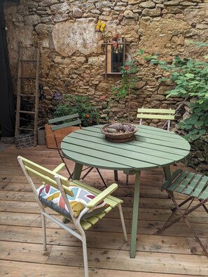 Relax in a charming outdoor space with a round table, woven basket, and comfortable seating.