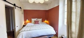 Cozy retreat with a bed, nightstand, and table with chair.
