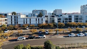 A modern urban area with contemporary buildings, a parking lot, and a clear blue sky.