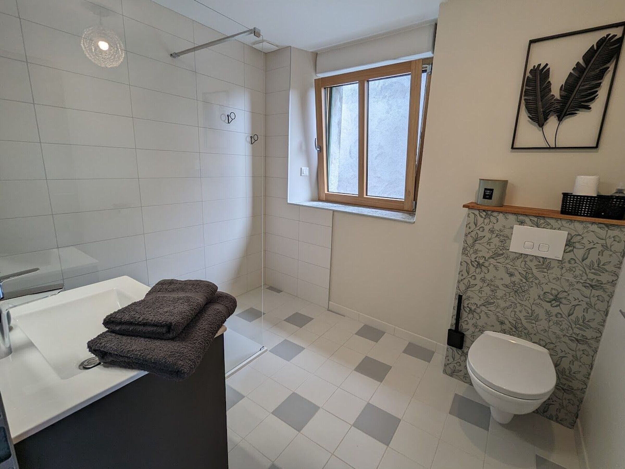 A bathroom with a shower, toilet, and sink.