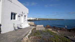 A white building with a small patio and a view of the sea. - Fischer Home Roque del Este (Punta Mujeres)