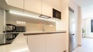 A modern kitchen with a built-in oven, a coffee maker, and a microwave.