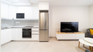 Una cocina moderna con horno empotrado, microondas y refrigerador de acero inoxidable.