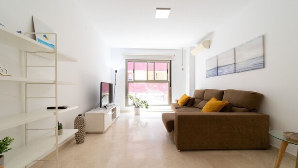Una sala de estar moderna con un sofá, un televisor y una estantería.