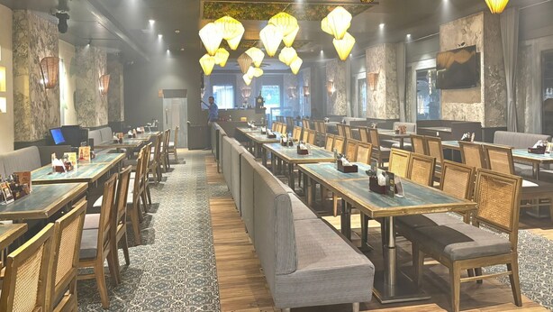 A restaurant with long communal tables, high ceiling with hanging paper lanterns, and a modern interior design. - Shelter Suites (Formerly known as Fisco The Hub Link) (Mumbai)