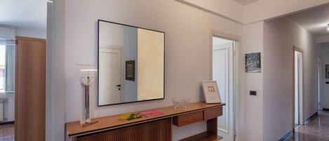 A hallway with a wooden console table, a mirror, and framed pictures on the wall.