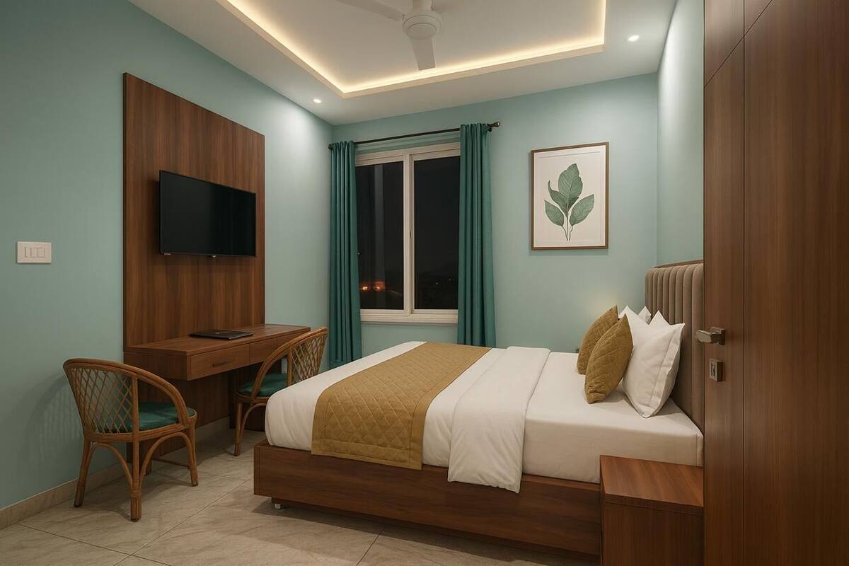 Quarto com cama, escrivaninha, cadeira, televisão e obras de arte.