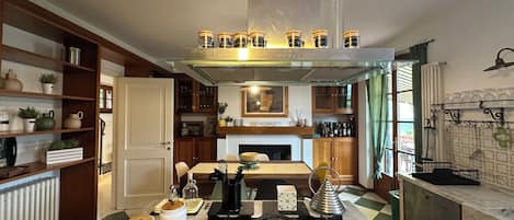 A modern kitchen with a central island, built-in shelves, and a variety of appliances.