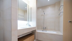 A modern bathroom with a large mirror, a sink, a shower, and a bathtub.