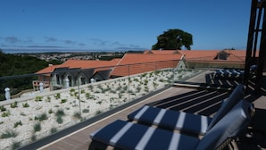 A rooftop terrace with lounge chairs and a view of the cityscape. - Quinta Da Maquia Hotel (Sintra)