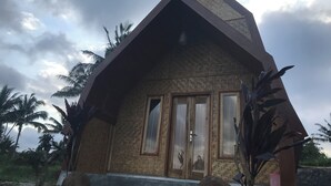 Ένα κτίριο με τριγωνική στέγη, ξύλινες πόρτες και πρόσοψη από τούβλα.