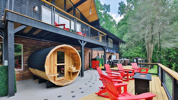 A wooden deck with red Adirondack chairs, a sauna, and a restaurant named "Blue Ridge." - Biltmore Forest Retreat! Sauna Hot tub Game Rm (Asheville)
