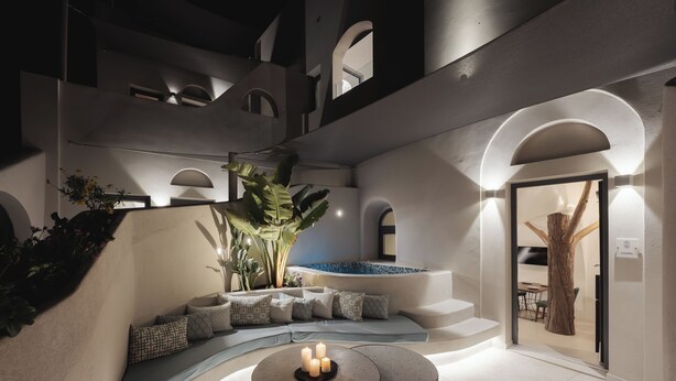 Et moderne udendørs opholdsområde med en pool, en træskulptur og en trappe op til en etage.