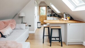 Une cuisine compacte dotée d’un plan de travail en bois, d’un meuble blanc et d’une lucarne.