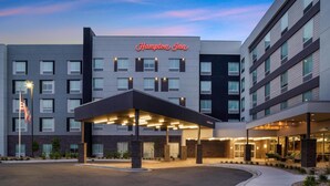 A Hampton Inn hotel with a modern design, featuring a covered entrance and multiple floors. - Home2 Suites Hilton Aurora Medical Center (Aurora)