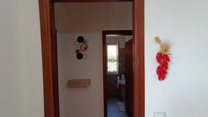 Un pasillo con una puerta de madera que da a un baño.