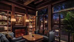 Una biblioteca acogedora con estanterías, chimenea y asientos cómodos.