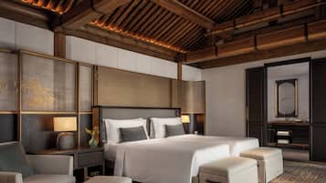A modern hotel room with a large bed, a sofa, a desk, and a mirror.