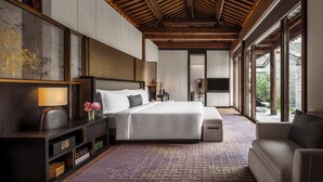 Un dormitorio moderno con una cama grande, un sofá y un televisor.