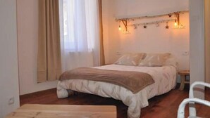 Une chambre à coucher avec un lit, une table de chevet, une chaise et une table en bois.