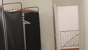 Une chambre avec un lit superposé, une petite table et un tableau blanc.