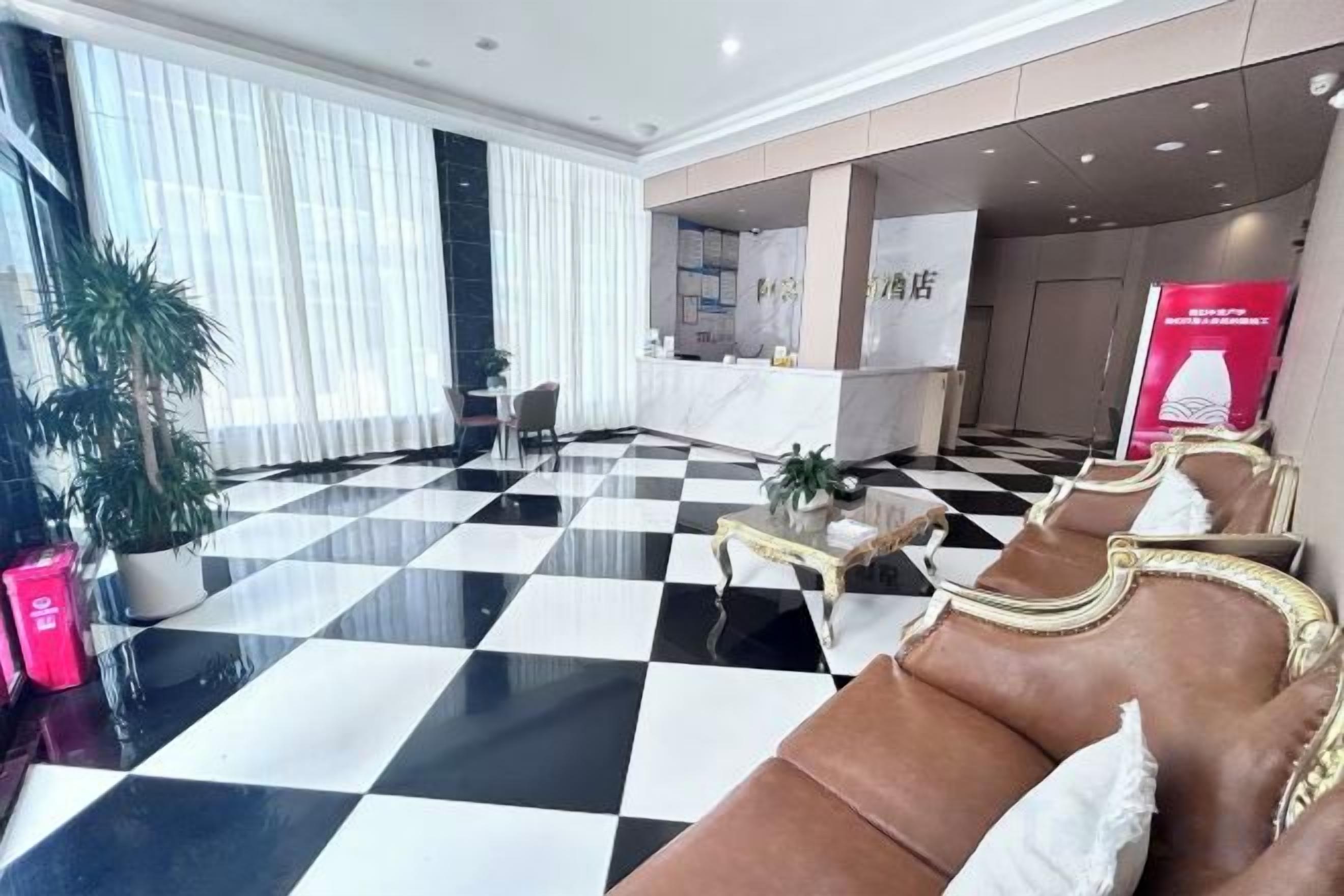 A lobby with a checkered floor, seating area, and a reception desk.