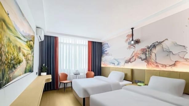 A hotel room with two beds, a desk, a chair, a window with curtains, and a wall with a painting. - afuerliansuozheyujiudian (Xiushan County)
