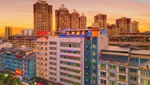 A high-rise hotel with multiple floors, large windows, and a prominent sign. - afuerliansuozheyujiudian (Xiushan County)