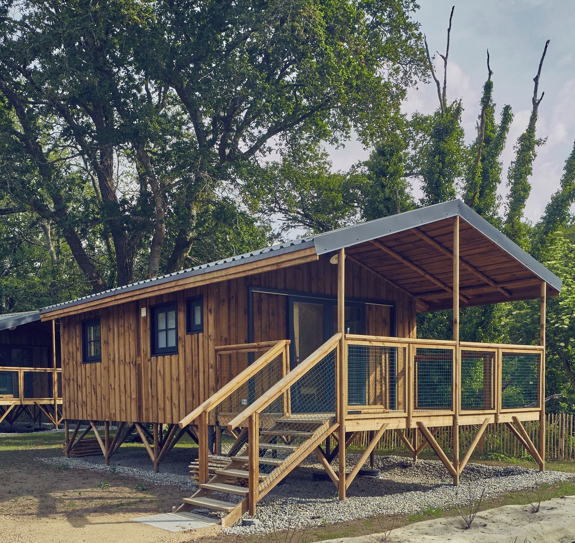 A wooden cabin with a covered porch and a staircase leading to the entrance.