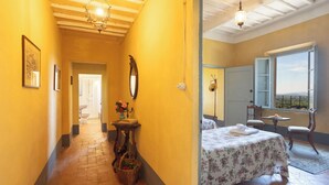 Une chambre d’hôtel comprenant un lit, une fenêtre avec vue, une salle de bain et un couloir avec une porte donnant accès à la salle de bain.