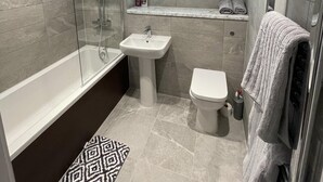 A modern bathroom with a glass-enclosed shower, a pedestal sink, a toilet, and a towel rack. - 5 Star Brand New Liverpool City Centre Apartment (Liverpool)