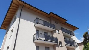 Un immeuble résidentiel à plusieurs étages, doté de balcons et d’un toit plat.