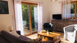 Una sala de estar con sofá, mesa de centro, televisor y aparador.