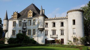 A large, historic building with multiple towers and a well-maintained garden. - Château Bagen (SAUVETERRE DE COMMINGES)