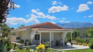 A house with a red-tiled roof, a covered porch, and a garden with various flowers. - Ornament:Infinite Nature Villa
Feel Nature, Enjoy Serenity, Live THE Experience! (Heraklion)