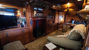 Un intérieur de chalet chaleureux avec une cheminée, des meubles en bois et un coin salon confortable.