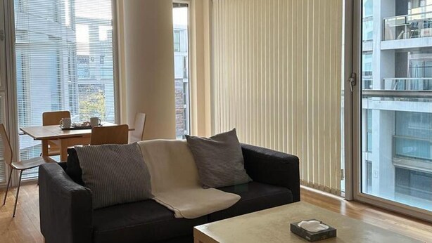 Una sala de estar moderna con sofá, mesa de centro y comedor.