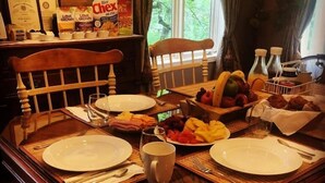 Ein Esstisch mit Geschirr, Besteck und einer Obstschale.