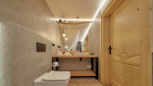 Une salle de bain moderne avec un meuble-lavabo en bois, un lavabo blanc et des toilettes.