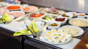A buffet with various dishes including eggs, salads, and meats.