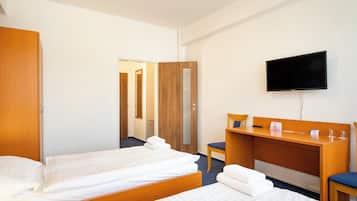 Habitación de hotel con dos camas, un escritorio, una silla, un televisor y un espejo.