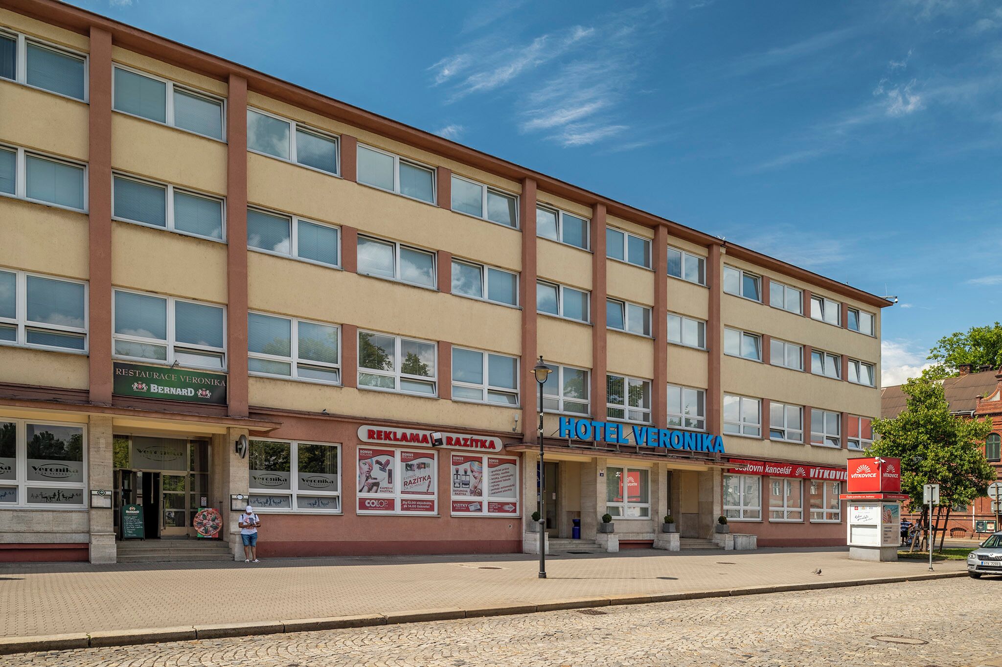 Un edificio de varios pisos con restaurante en la planta baja y un hotel.